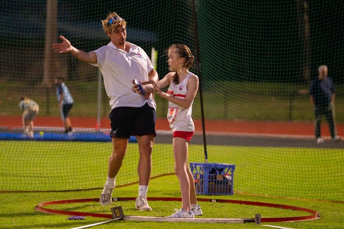 Coach working with an athlete in the discus circle