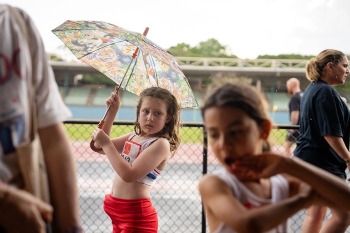 An athlete sheltering under an umbrella trackside at ES Marks